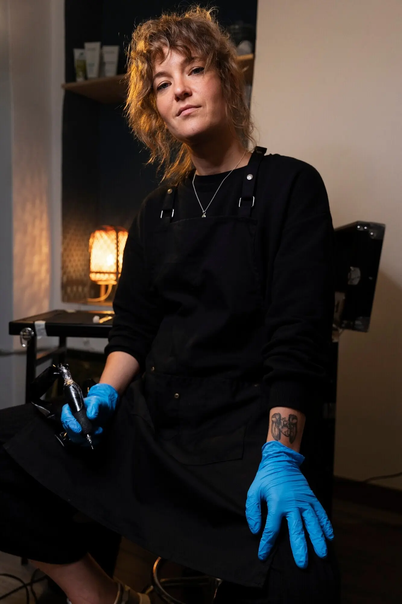 Средний план улыбающегося тату-мастера в помещении.